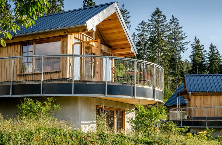 Unsere Nester im Bergdorf LiebesGrün Außenansicht Nest mit einem Balkon mit Wald im Hintergrund
