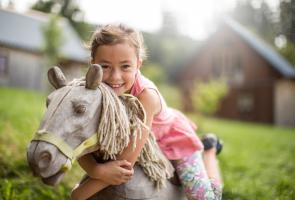 Familienzeit im Bergdorf LiebesGrün Kind auf Spielplatz im Hintergrund Bergdorf