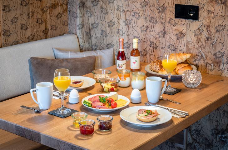 Gedeckter Frühstückstisch in Berghütte mit regionalen Produkten