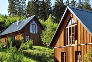 Außenansicht Berghütten mit Bäumen und Natur.