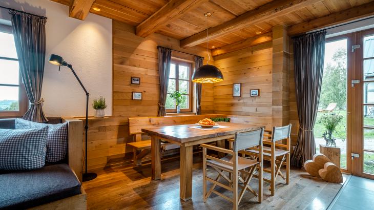 Wohnbereich in Berghütte mit Holztisch und Holzstühlen und Naturblick