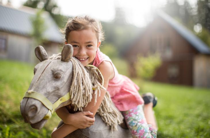 Kind auf Spielplatz im Hintergrund Bergdorf
