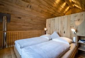Doppelbett im Obergeschoss unseres Bergchalets Doppelbett mit Naturmaterialien und Naturblick