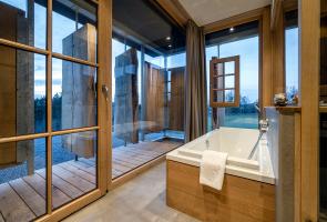 Badewanne im Natur-Wellnessbereich Badewanne im Natur-Wellnessbereich mit drehbaren Eichenportalen und in die Natur