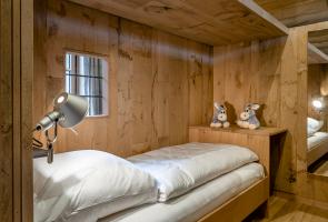 Gemütliches Einzelbett im Obergeschoss unseres Bergchalets Einzelbett im Bergchalet mit Holzwänden