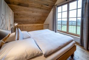 Doppelbett im Obergeschoss unseres Bergchalets Doppelbett mit Naturmaterialien und Naturblick