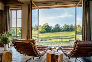 Bergchalet Ausblick aus dem Wohnraum mit Lederliegen Bergchalet Ausblick in die grüne Natur