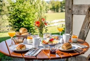 Frisches Bergfrühstück serviert und geliefert in Ihre Berghütte Gedeckter Frühstückstisch in Berghütte mit regionalen Produkten