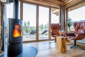 Flackernder Kamin neben gemütlichen hochwertigen Ledersesseln