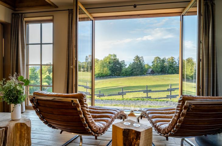Bergchalet Ausblick aus dem Wohnraum mit Lederliegen Bergchalet Ausblick in die grüne Natur