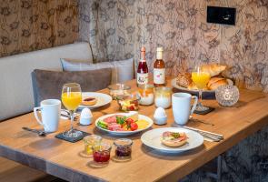 Gedeckter Frühstückstisch in Berghütte mit regionalen Produkten