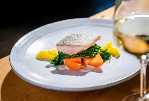 Slow Food Hauptgang Gebratene Lachsforelle auf Spinatgemüse