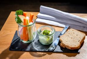 Menüvorspeise serviert am Tisch mit Brot, frischen Vitaminen und Dip
