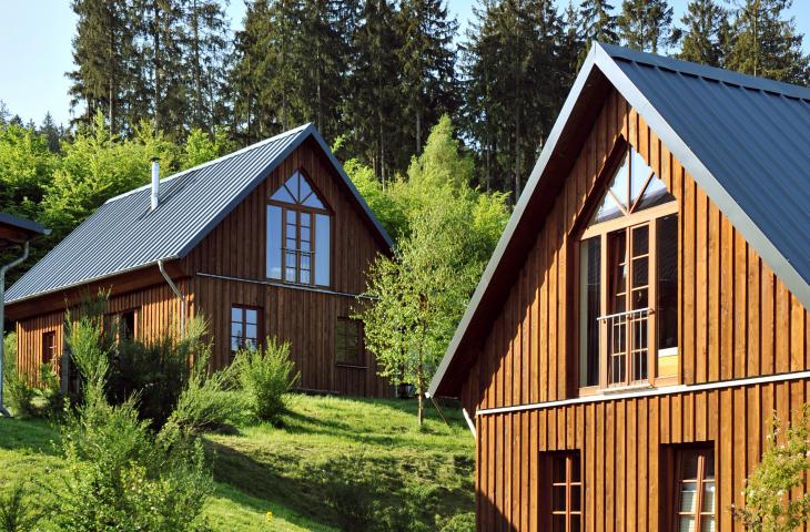 Außenansicht Berghütten mit Bäumen und Natur.